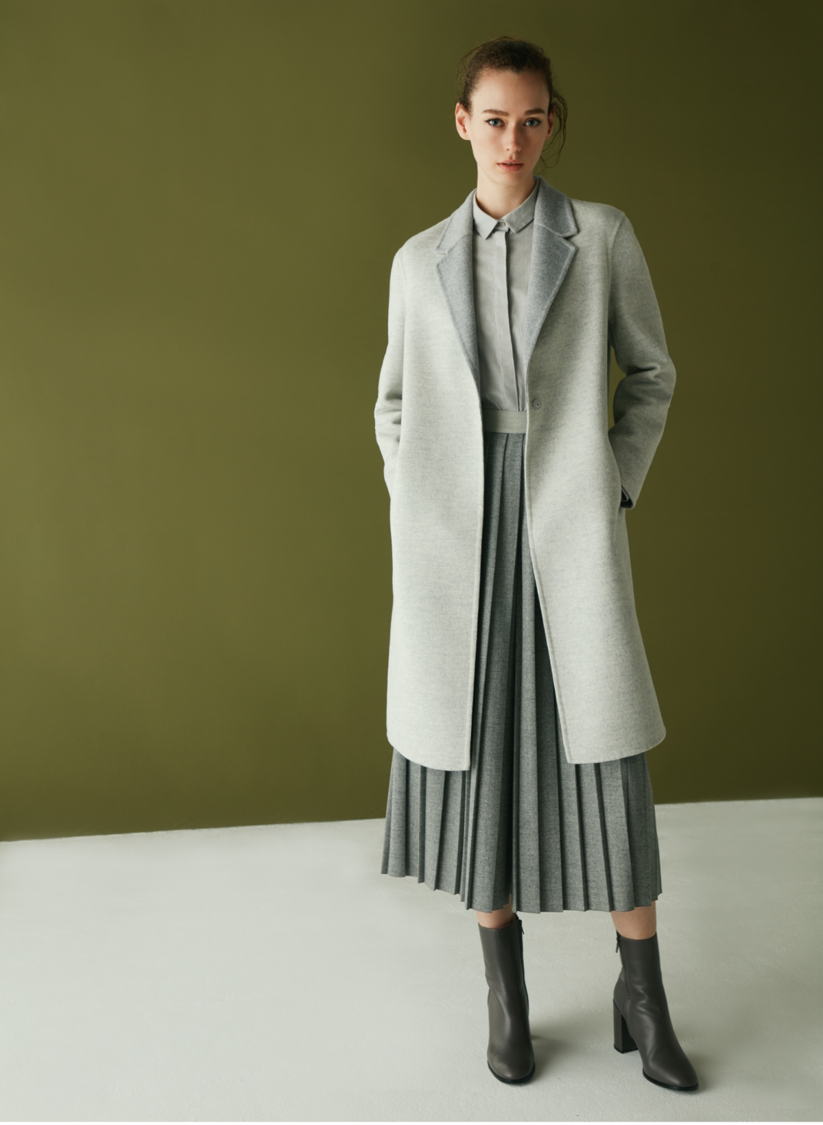同系色のバイカラーコートとプリーツがワントーンに複雑さをプラス
